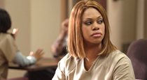 actor laverne cox, dressed in prison garb and wearing a prison ID, in a scene from "orange is the new black."